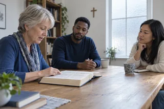 Scène contemporaine imaginée : trois adultes lisent et écoutent un passage biblique autour d’une table.